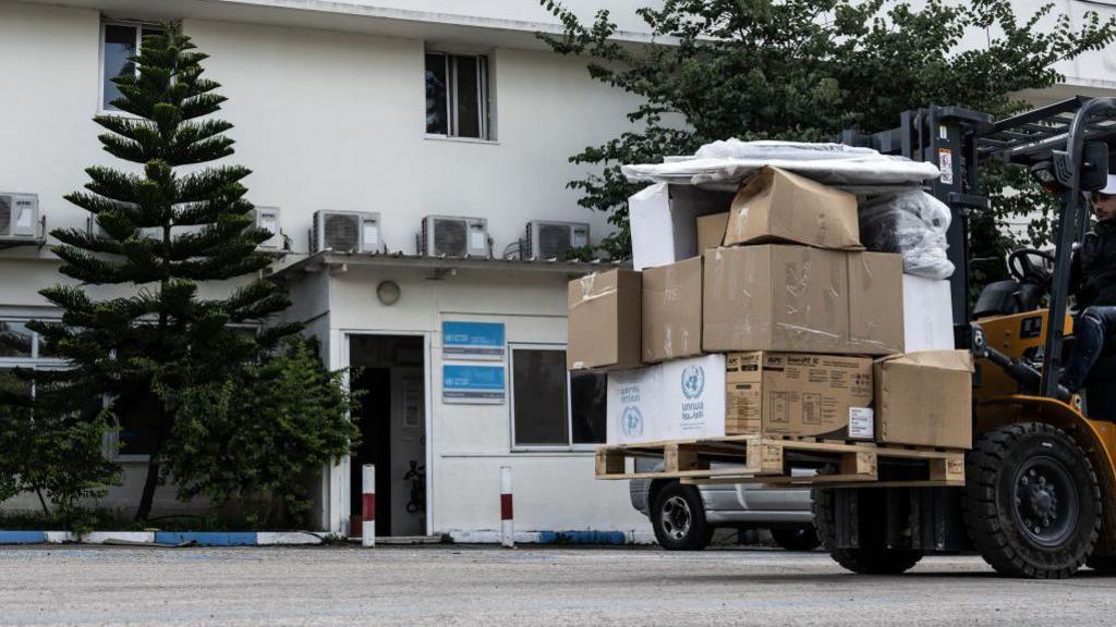 A dozen Unrwa boxes are stacked in the back of a tractor in front of the agency's headquarters in Jerusalem on 28 January