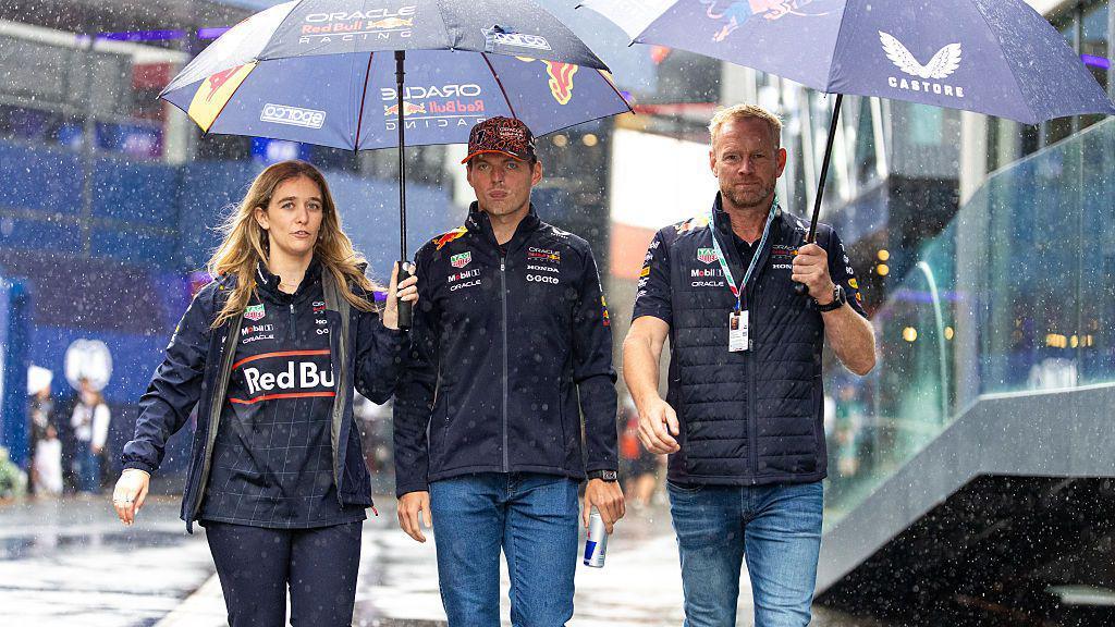 Max Verstappen walks under an umbrella in the Zandvoort paddock 