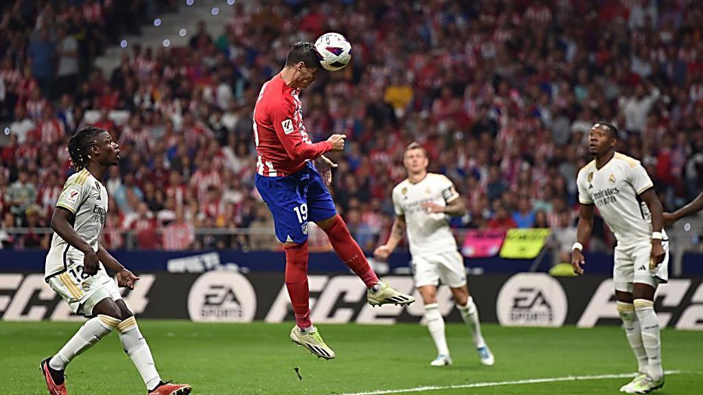 Alvaro Morata wins a header while Real players watch on