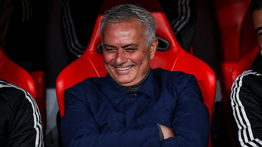 Jose Mourinho smiles and folds his arms