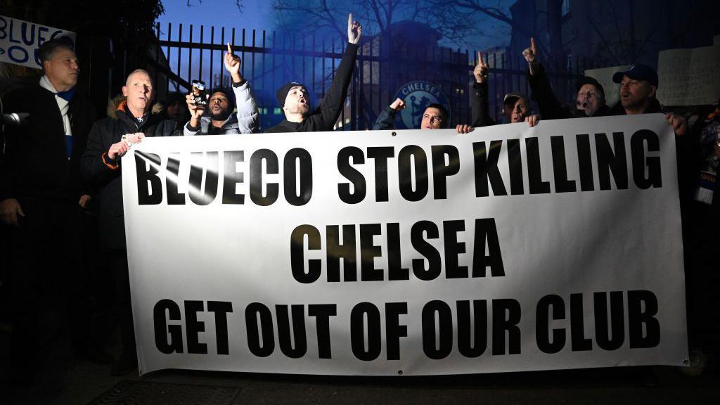 Fans of Chelsea are seen holding a banner during a protest against BlueCo, the consortium Led by Chelsea Owner Todd Boehly, Clearlake Capital, Mark Walter, and Hansjorg Wyss 