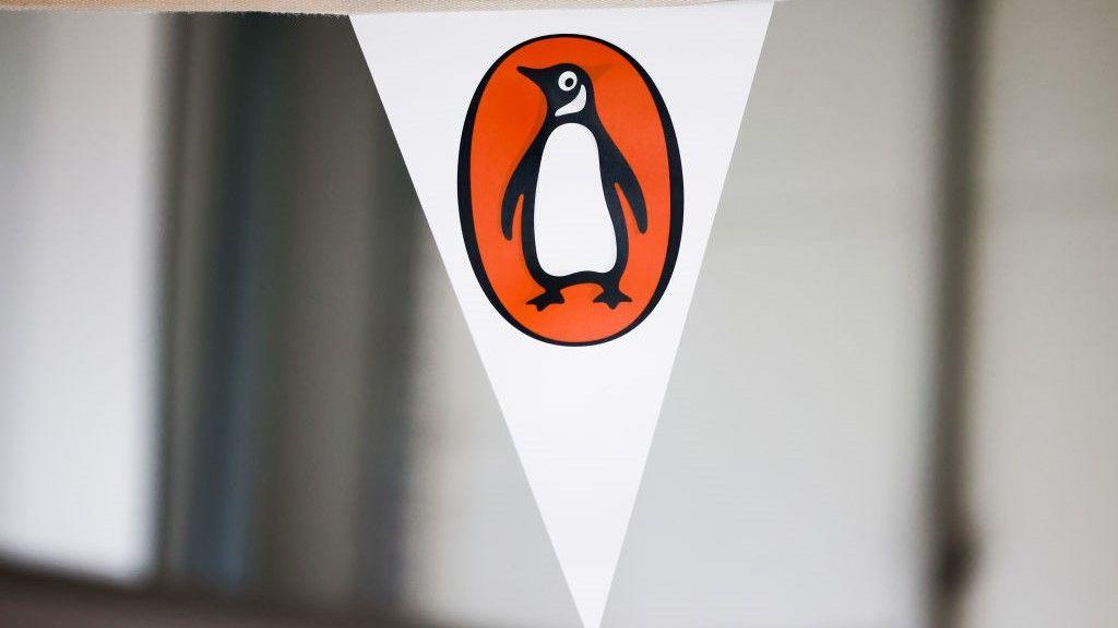 Close-up image shows the black, white and orange Penguin logo on a triangular white pennant.
