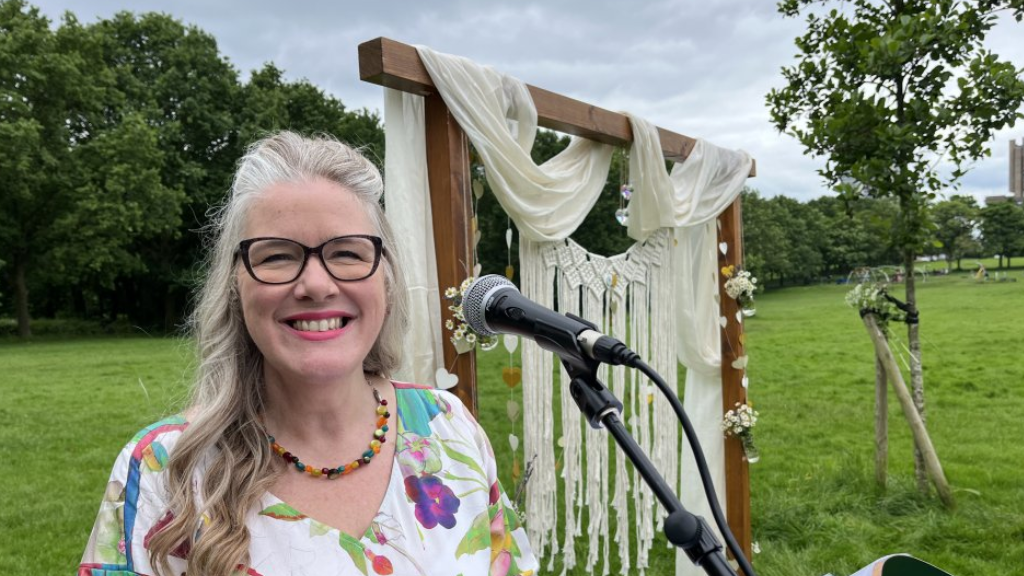 celebrant Rachael Parker stands at her lecturn with the wedding arch behind her