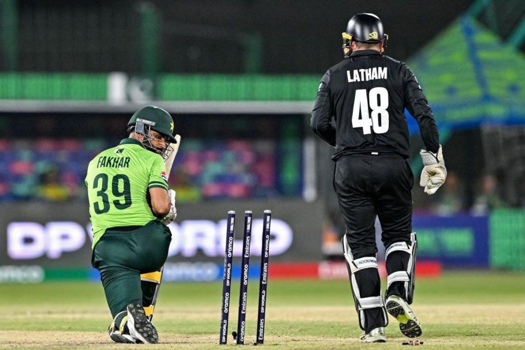 Pakistan's Fakhar Zaman (L) looks at the stumps after being clean bowled during the ICC Champions Trophy cricket match between Pakistan and New Zealand at the National Stadium in Karachi on February 19, 2025.