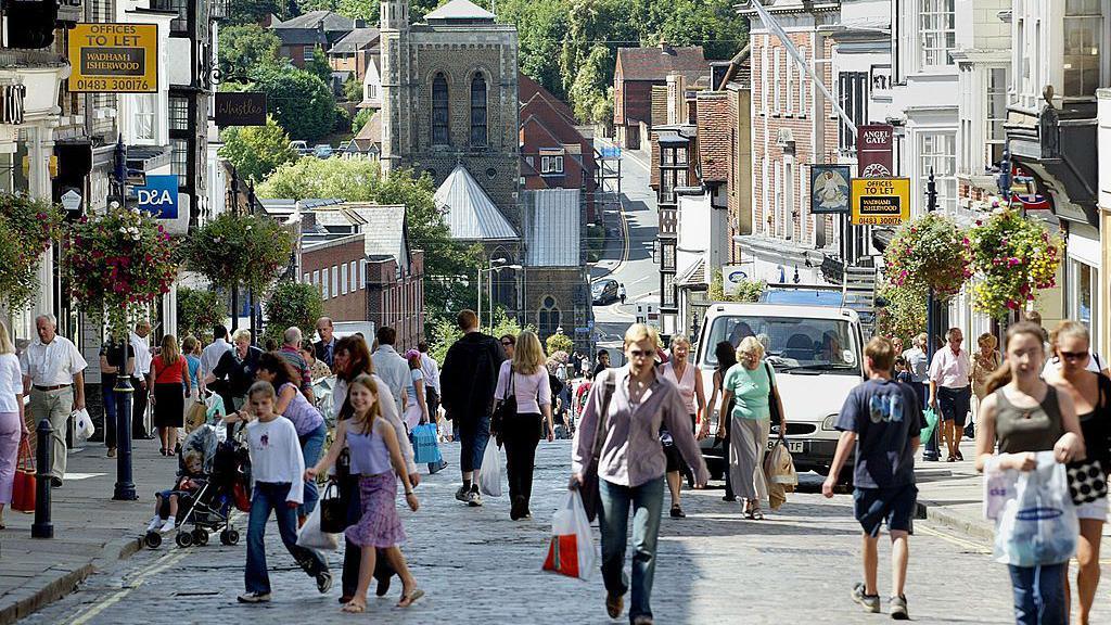 A busy town centre with lots of people walking around.