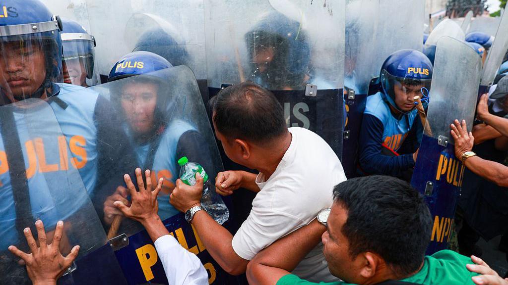 Protesters clash with riot police as officers attempt to disperse them while thousands of people occupy major roads during a protest against corruption near the EDSA People Power Monument in Quezon City, Metro Manila, Philippines, on June 30, 2026