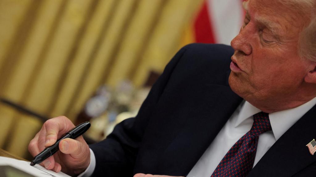 Donald Trump signing a document with a sharpie