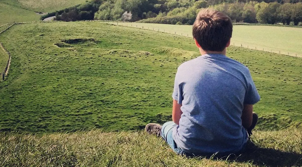 Child sitting on a hill