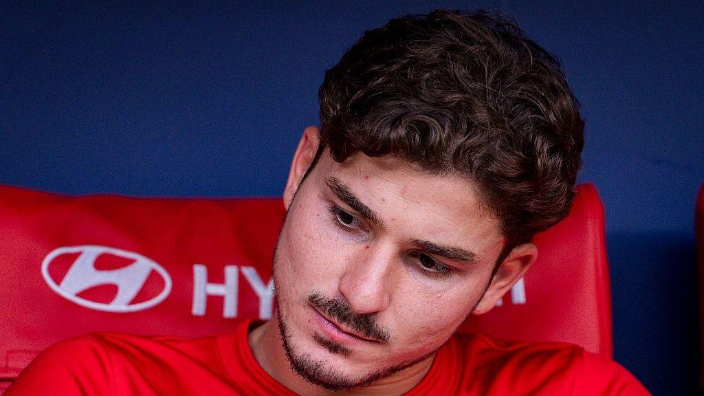 Julian Alvarez looks down sitting on the bench at an Atletico Madrid game