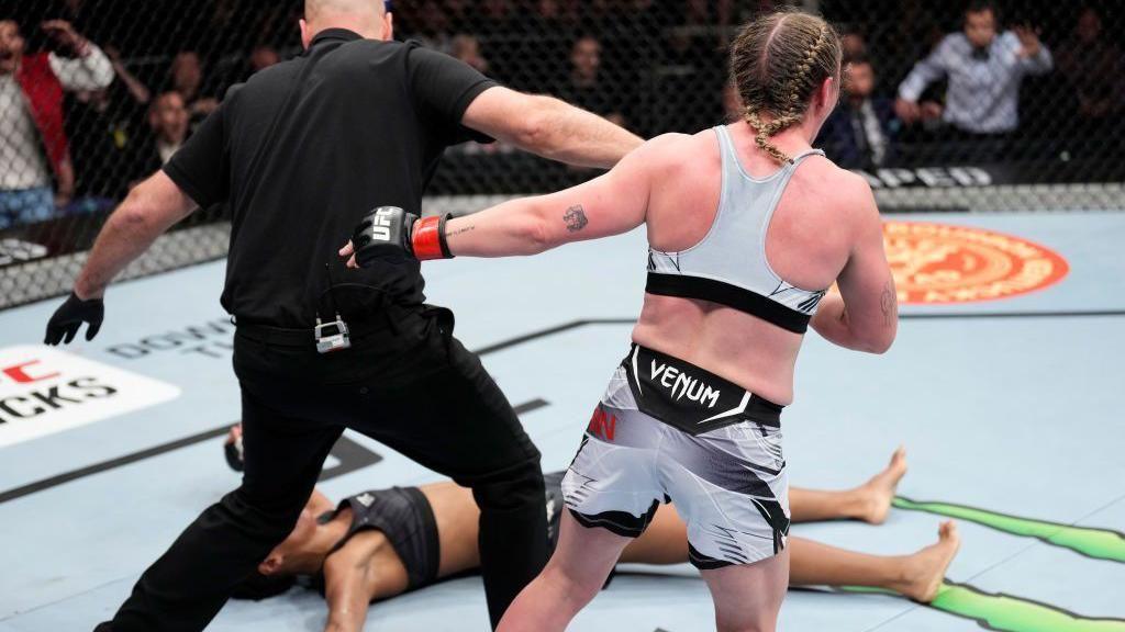 Molly McCann celebrates with her opponent on the canvas