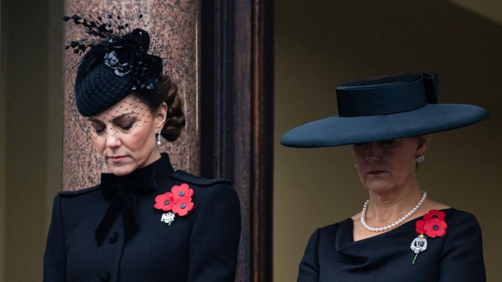 The Princess of Wales and Duchess of Edinburgh bow their heads on the balcony of the Foreign Office building 