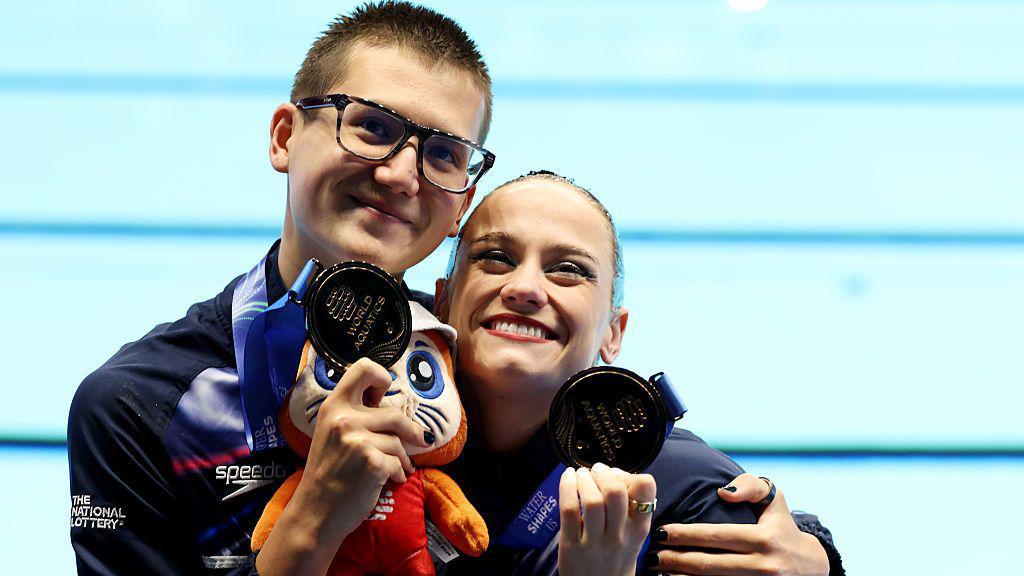 Izzy Thorpe and Ranjuo Tomblin smiling while holding up their bronze medals