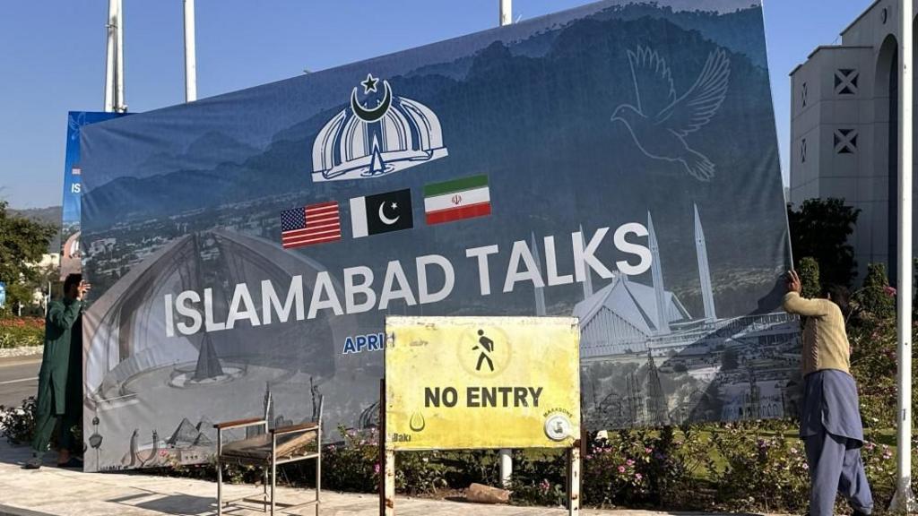 Laborers remove billboards after the peace talks between US and Iran ends in Islamabad.