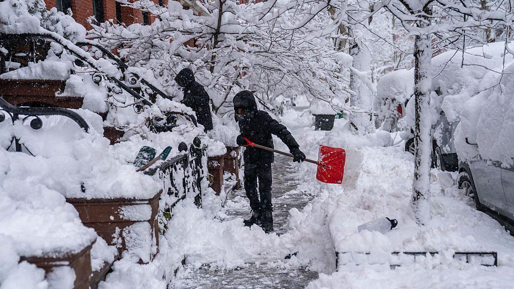two men shovelling snow in new york