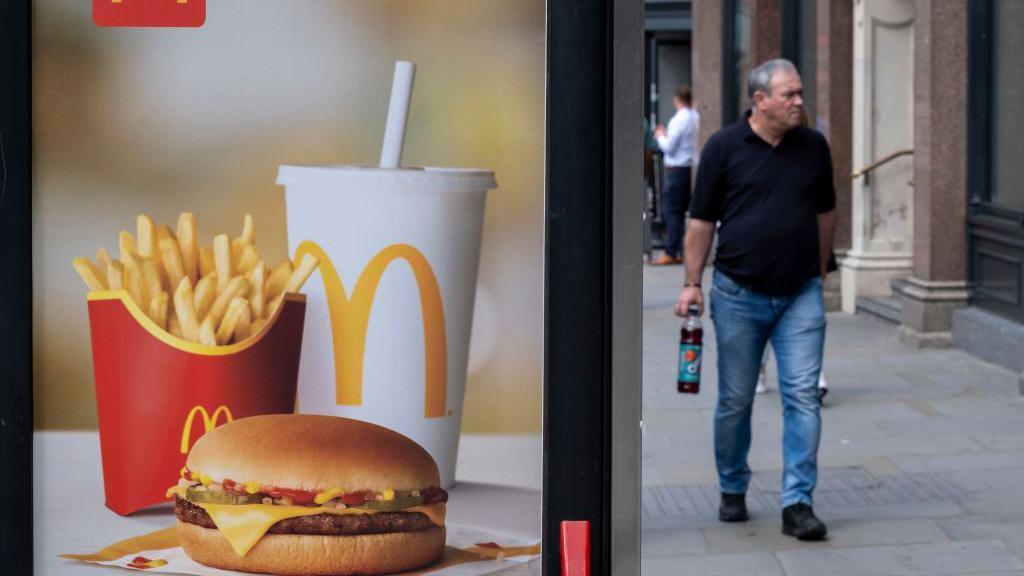 A man walks past a McDonald's ad in July 2023 in the UK