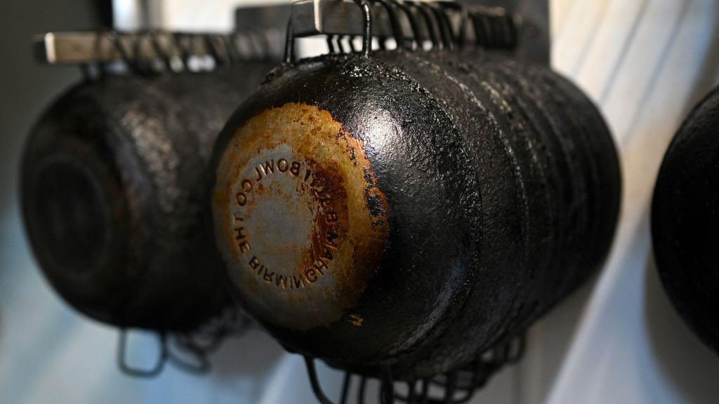 black balti pans hung up on a rack