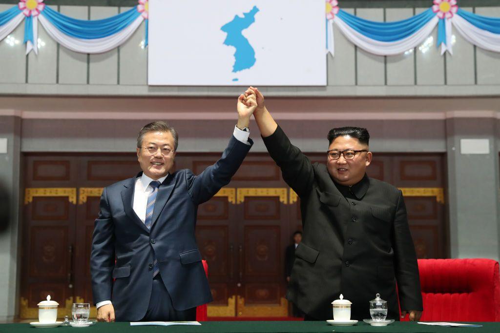 North Korean leader Kim Jong Un, left, and South Korean President Moon Jae-in, right, raise hands together