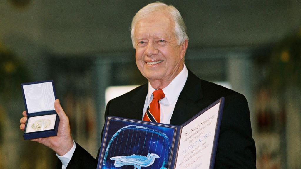 Jimmy Carter holds up his Nobel Peace Prize Oslo, Norway, in 2002.