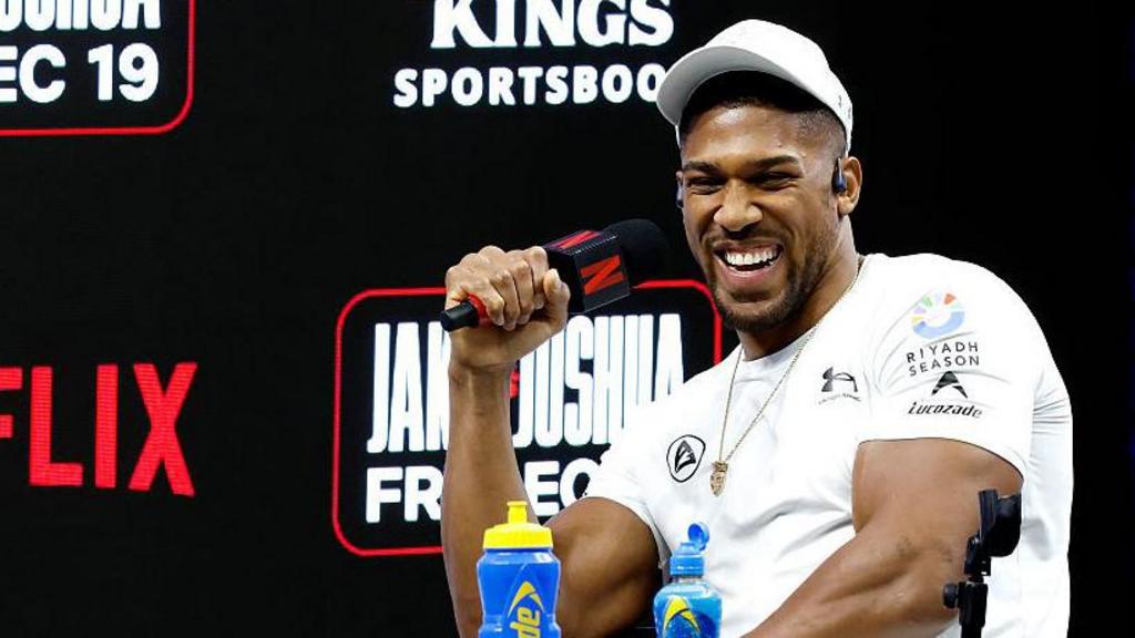 Anthony Joshua laughs at a news conference