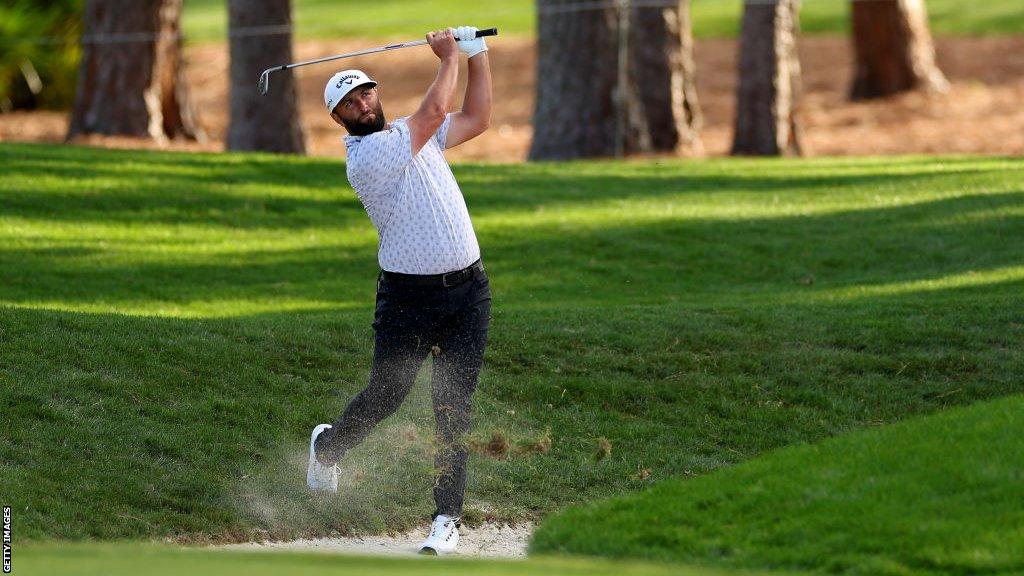 Jon Rahm playing out of a bunker at Sawgrass