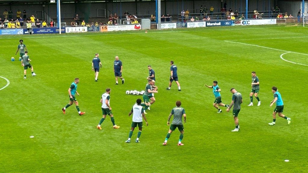 Norwich players warm up before the game against King's Lynn at The Walks