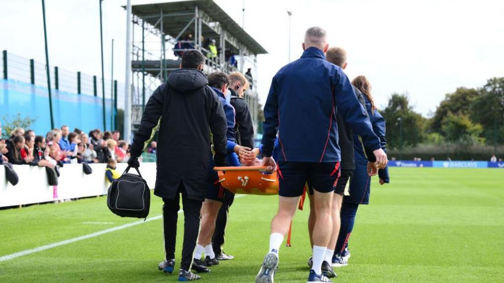 Inma Gabarro being taken off on a stretcher against Manchester United