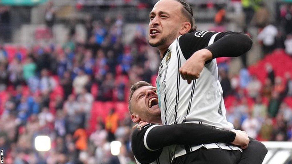 Jodi Jones is hugged by a Notts County team-mate after they sealed promotion back to the English Football League