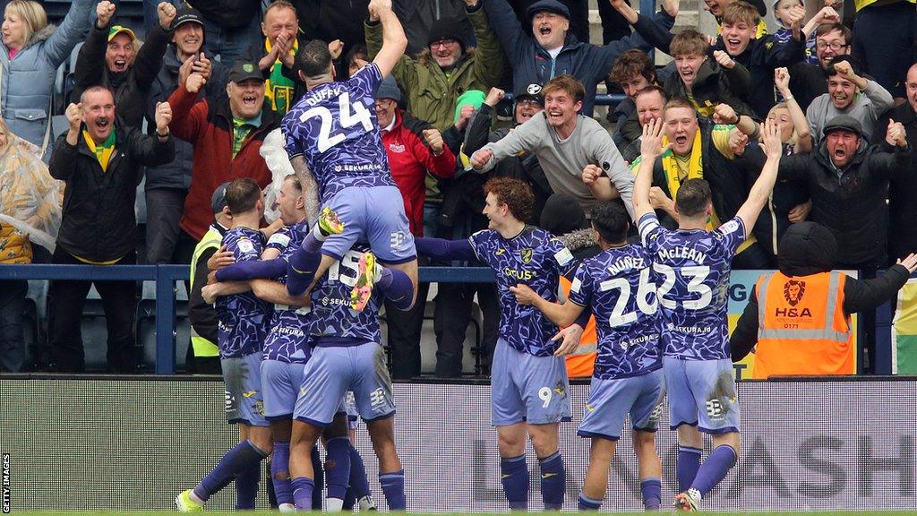 Norwich City players celebrate in front of their travelling fans