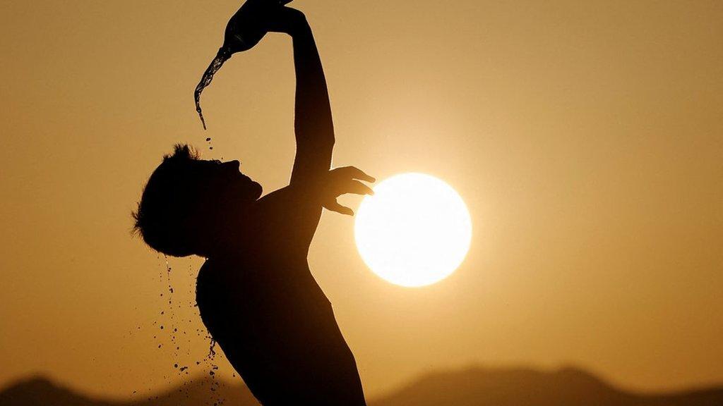 A person pouring water on themselves