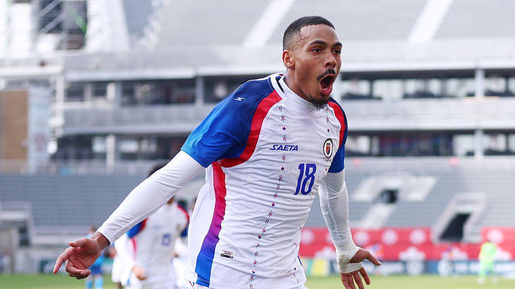 Wilson Isidor celebrating in a white Haiti kit