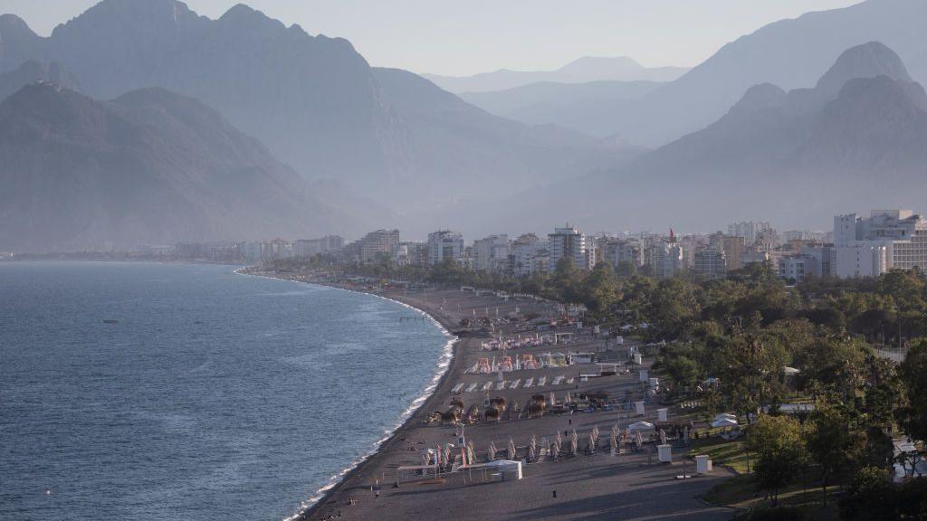 People walk on a near empty Konyaalti beach during a weekend lockdown on 06 June, 2021 in Antalya, Turkey.