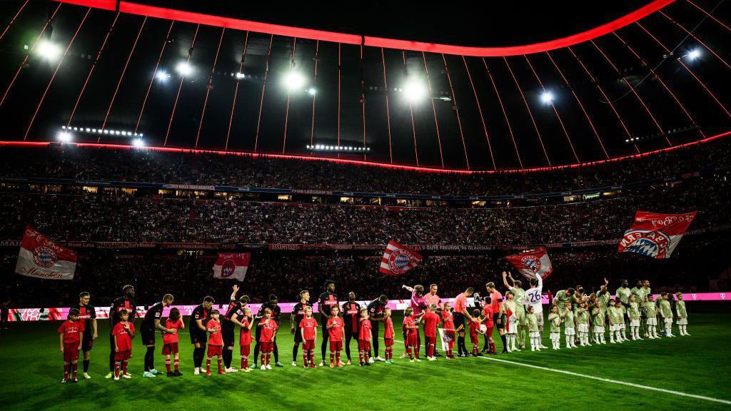 Bayern Munich and Bayer Leverkusen players line up pre-match in 2023