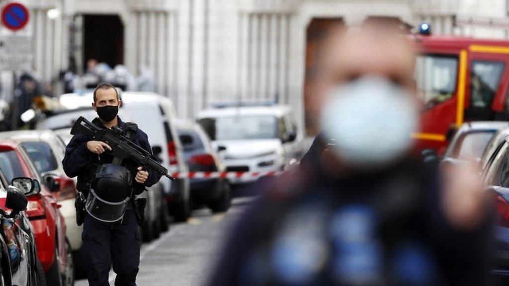 Armed French police officers secure the street near the entrance of the Notre-Dame Basilica church in Nice, France,