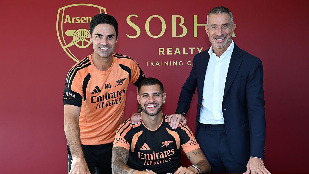 New Arsenal signing Bruno Guimaraes poses for a photograph with manager Mikel Arteta and sporting director Andrea Berta