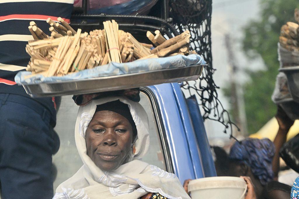 Women carry their loads either on their heads or on their backs as they continue their daily life on one of the world's poorest countries and a small nation in West Africa in Lome, Togo on June 13, 2025.