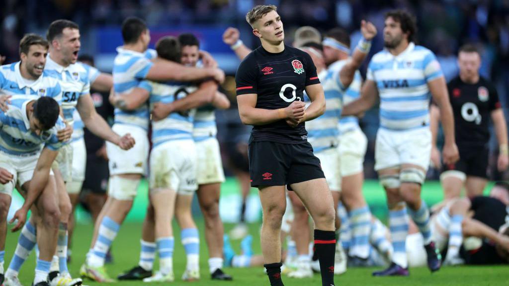 England scrum-half Jack van Poortvliet looks dejected as Argentina players celebrate behind him