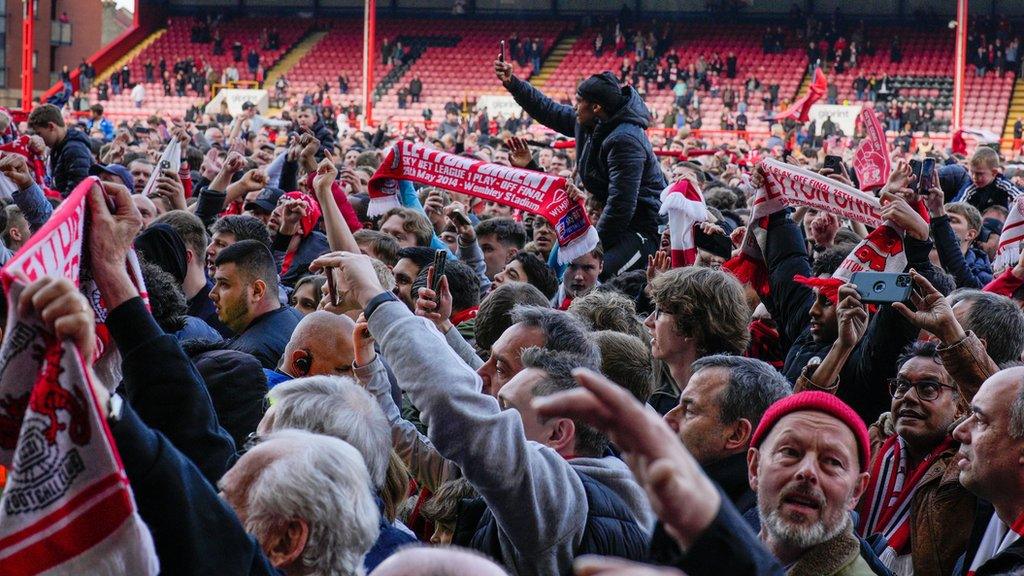 Orient fans celebrate on the pitch after sealing the title