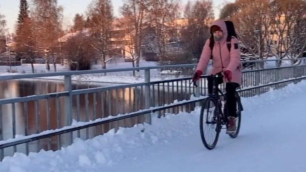 Person cycling in the snow in Oulu, Finland