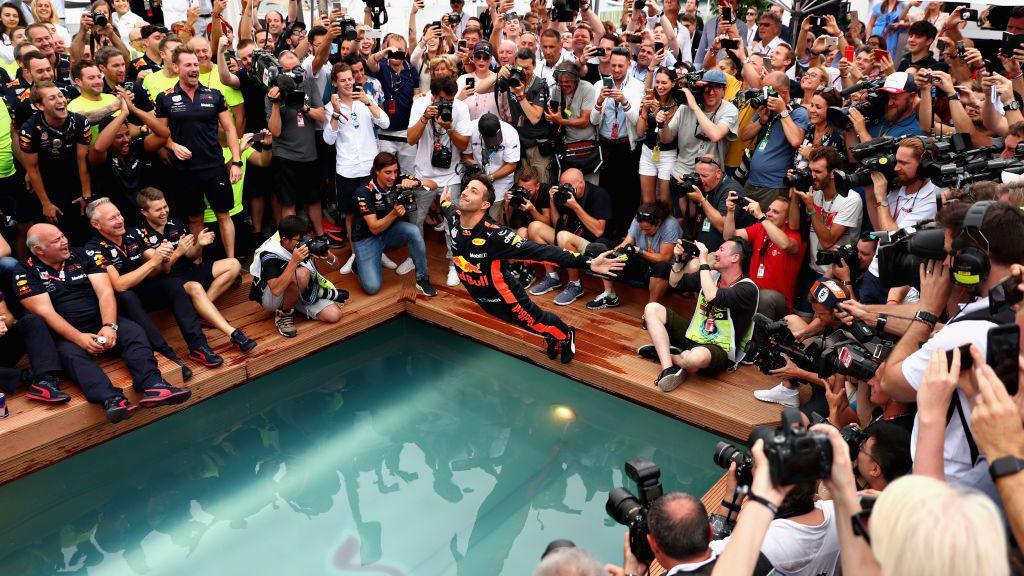 Daniel Ricciardo does a swan dive into a pool after his 2018 win in Monaco