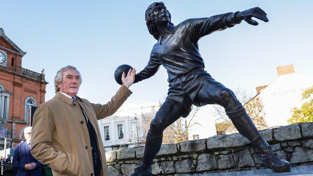 Jennings poses for photographs in front of the statue