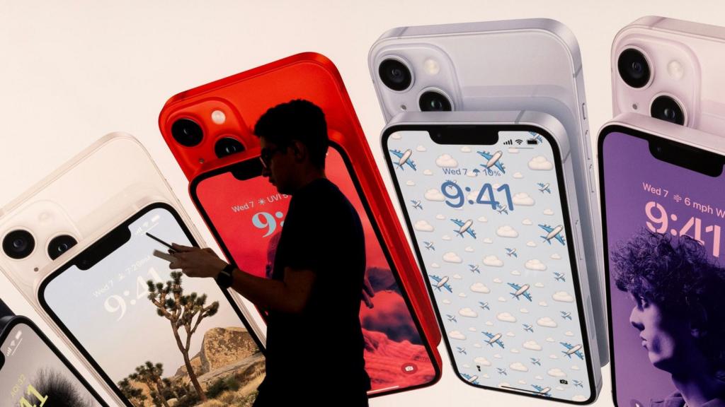 An employee walks past a sign showing iPhones at an Apple store in Washington, D