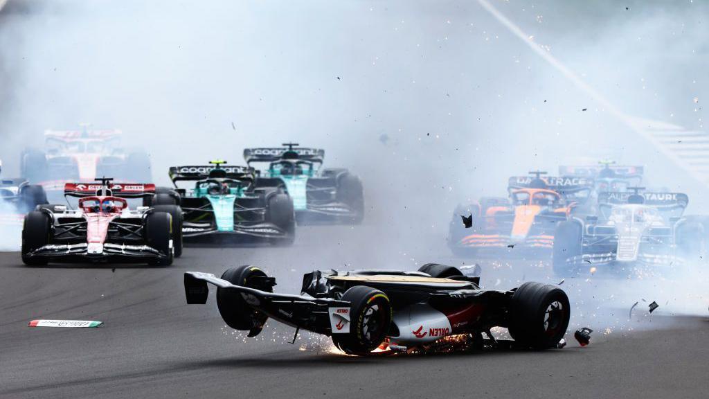 The Alfa Romeo of Zhou Guanyu upside down at the first corner in 2022. Zhou's car vaulted the barriers, but he was freed from the car by paramedics and was uninjured