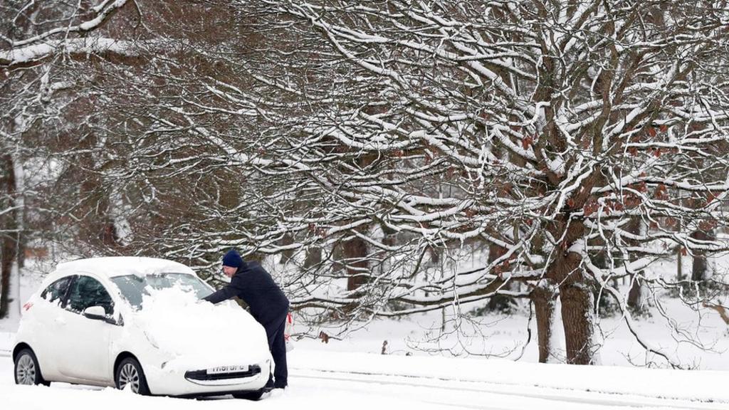 Motorist clears car of snow