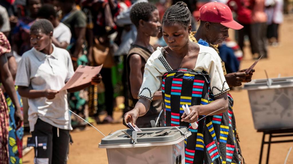 A woman in a colourful wrap votes at on outdoor polling station in Lilongwe - 16 September 2025
