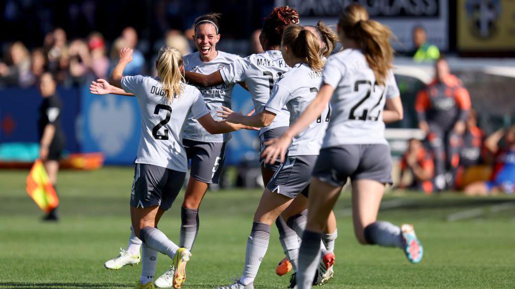 Deanna Cooper celebrating with Reading players after scoring a goal