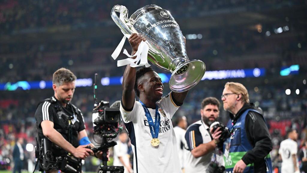 Vinicius Jr olds aloft the Champions League trophy