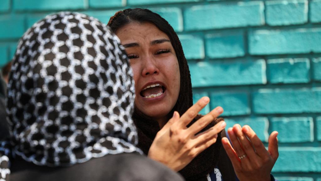 A woman looks upset next to the site of a residential building damaged by a strike, amid the U.S.-Israeli conflict with Iran, in Tehran, Iran, March 27, 2026.