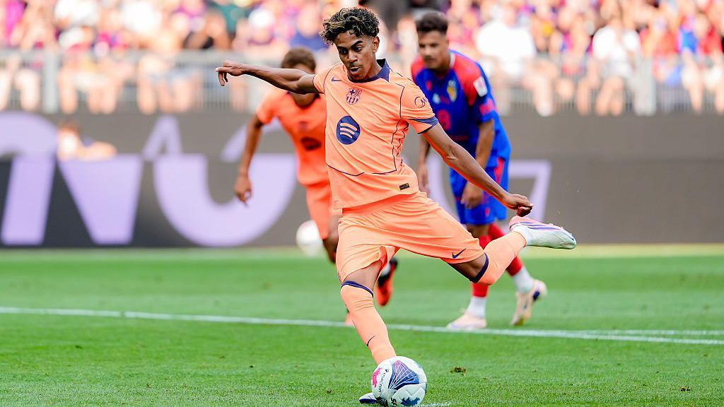 Lamine Yamal prepares to strike the ball with his left foot, as he wears the team's salmon-coloured change kit