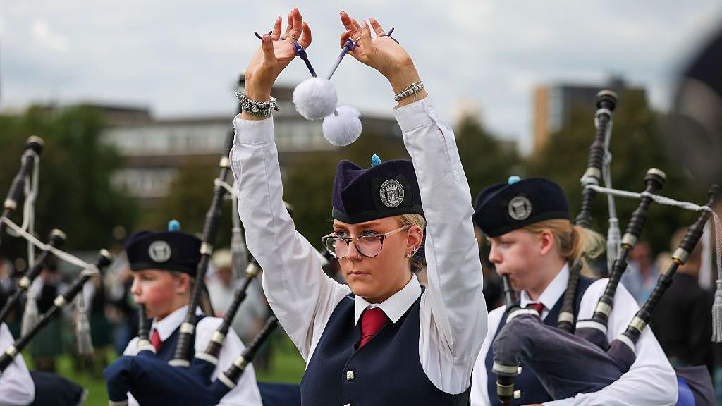 A tenor drummer performing at the World Pipe Band Championships as part of a young pipe band