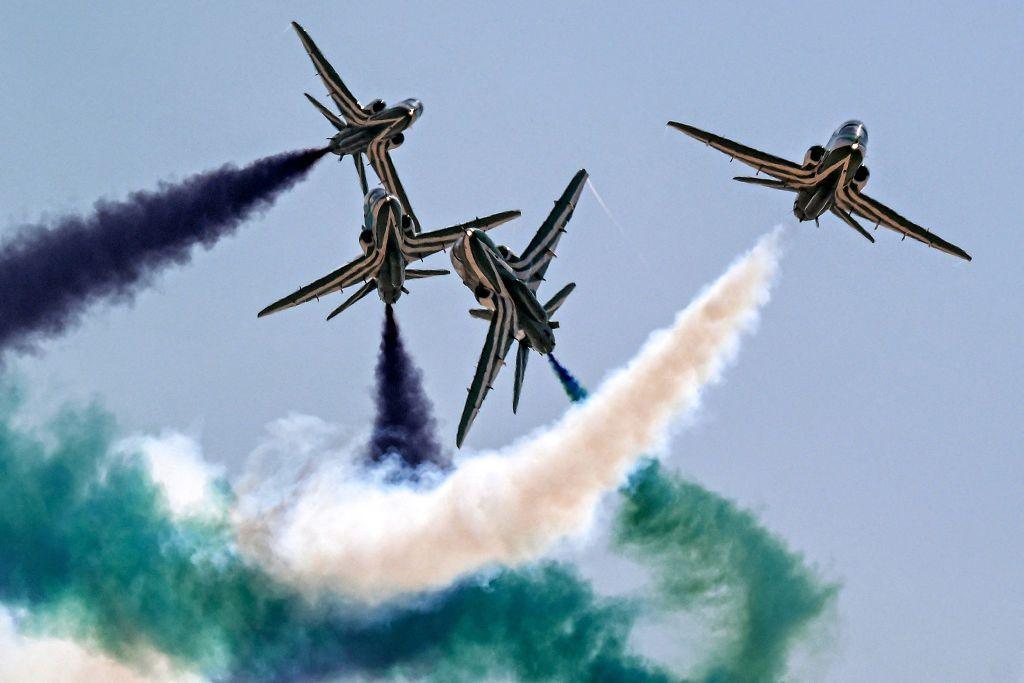 BAE Hawk trainer aircraft of the Royal Saudi Air Force's Saudi Falcons aerobatic team release smoke as they cross in flight